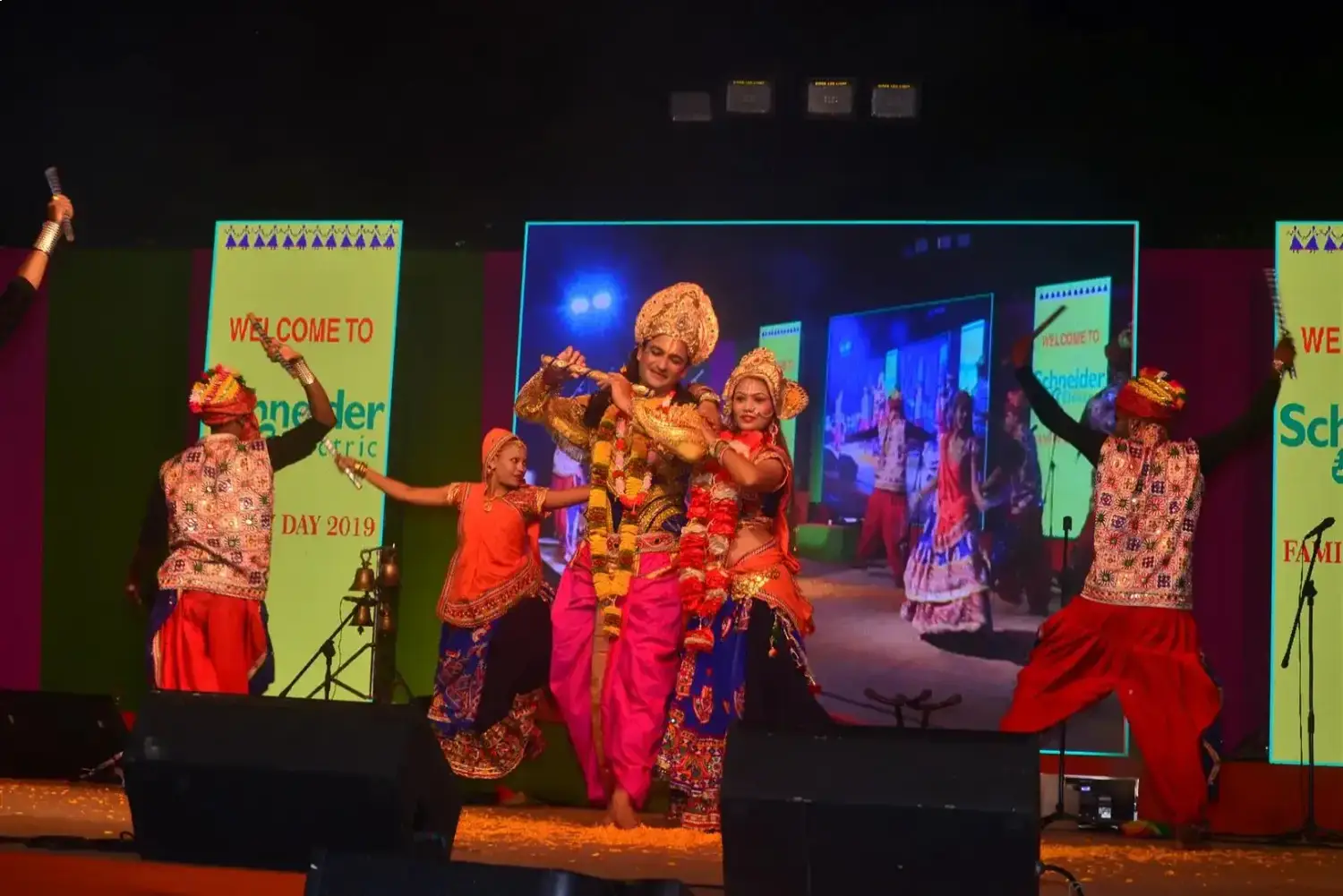 Man and woman speaking on stage at night with blue lighting